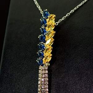 Брошка в позолоте з желтыми, синими та белыми фианитами